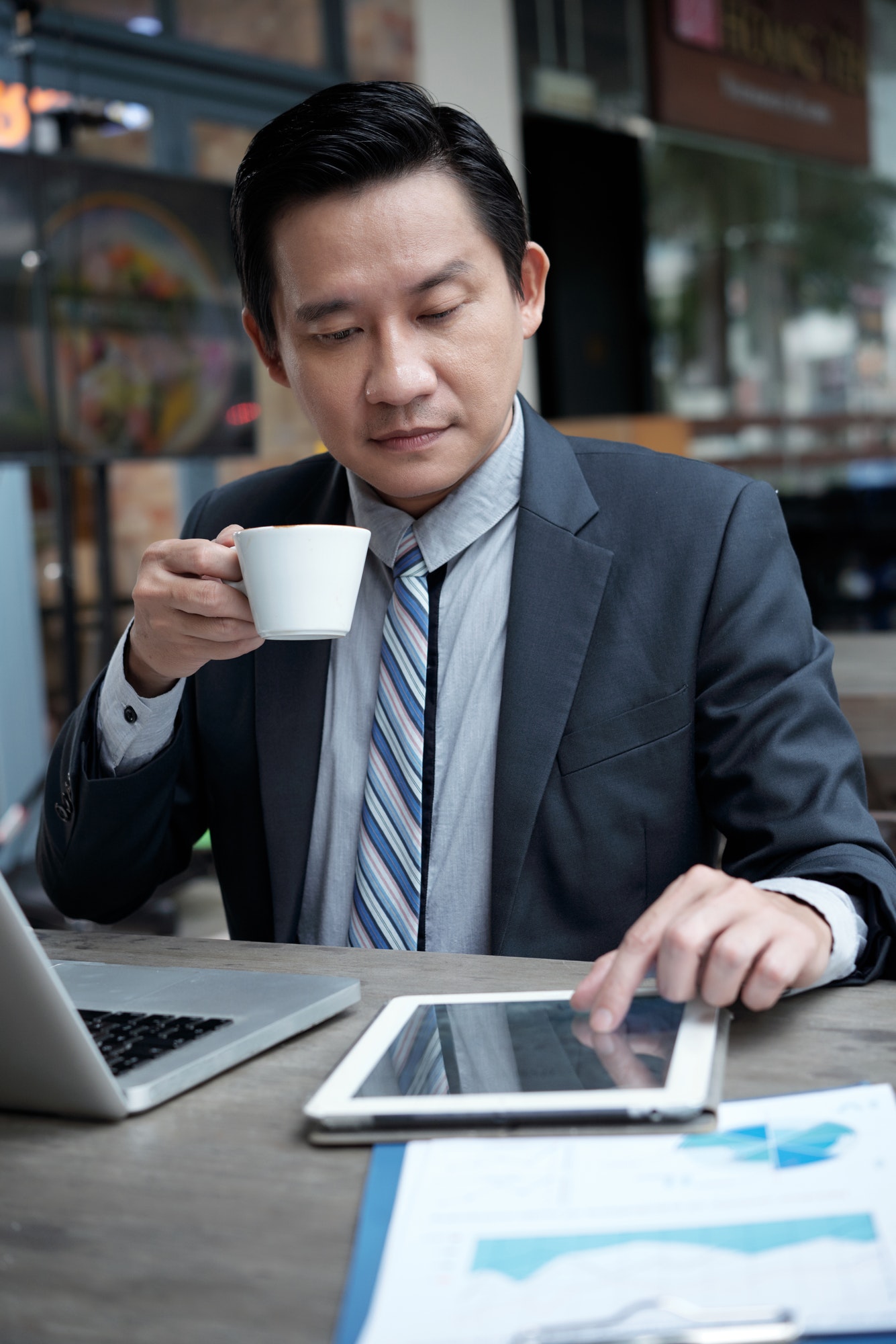 Businessman drinking coffee and reading news online